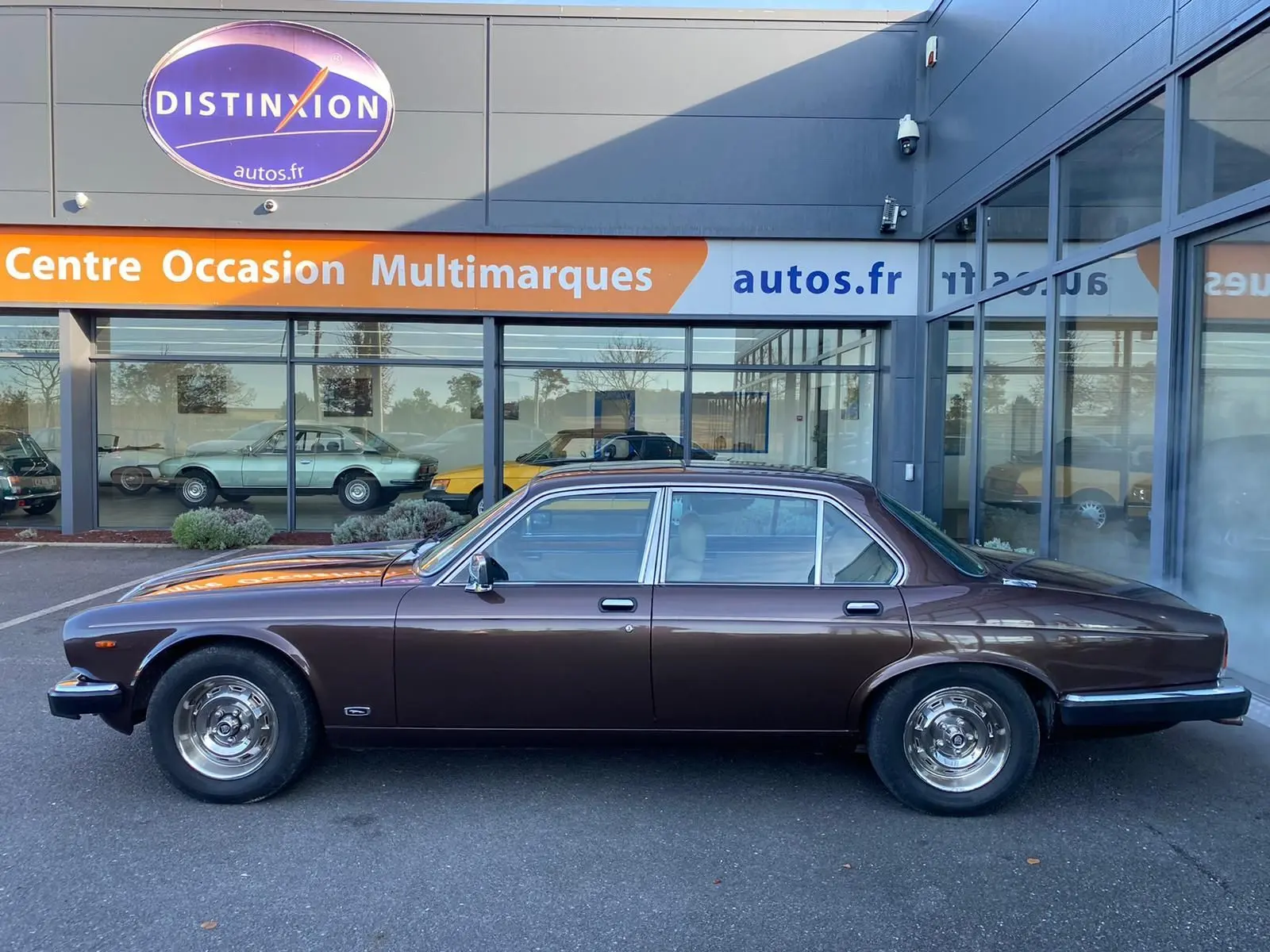 Profil côté gauche d'une Jaguar XJ6 Série 3 4.2 Sovereign marron de 1985 avec jantes chromées et carrosserie lisse.