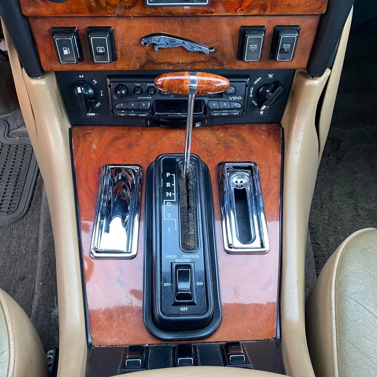 Gros plan sur la console centrale marron en bois verni de la Jaguar XJ6 Série 3 4.2 Sovereign avec levier de vitesse automatique.