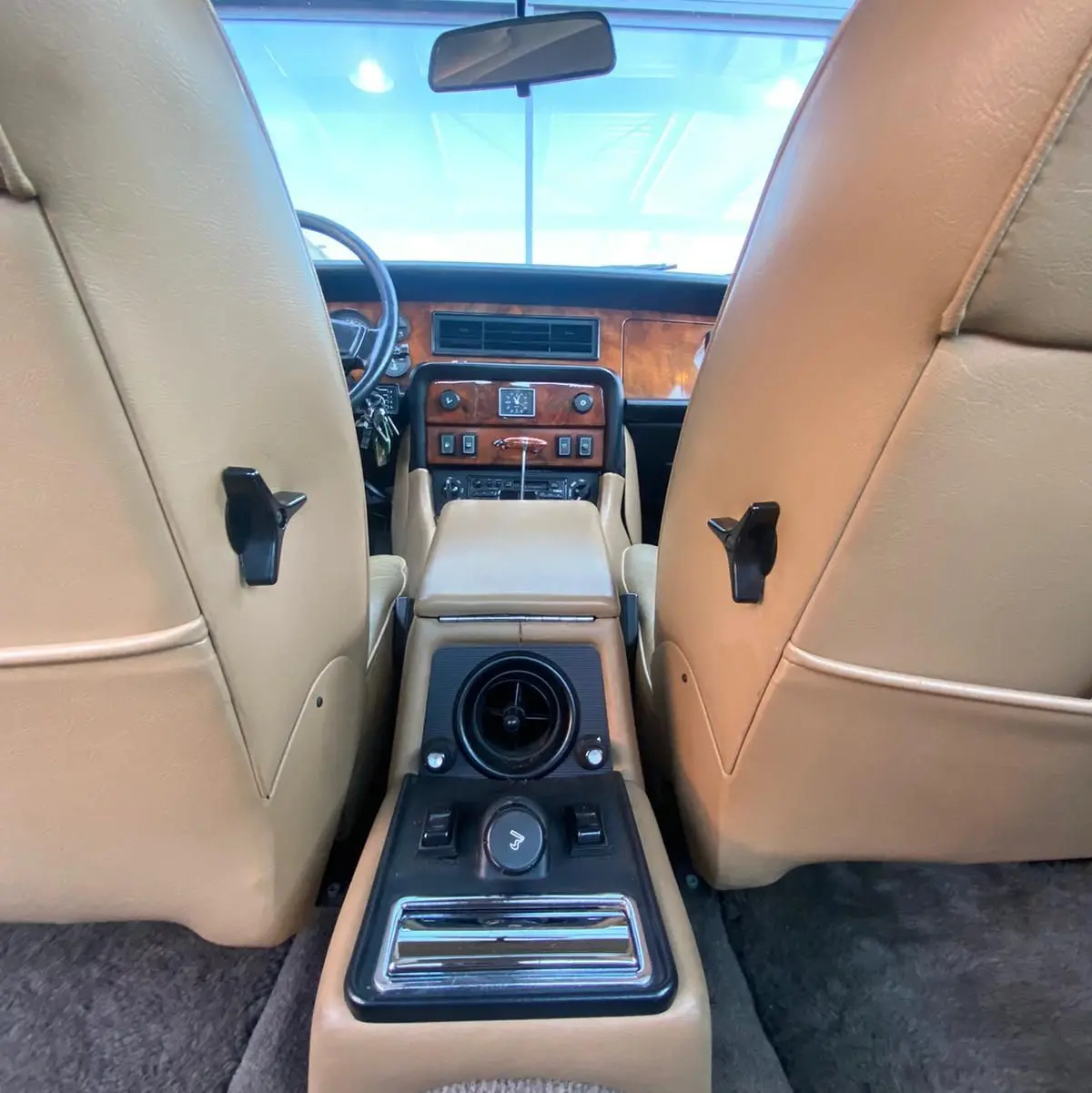 Vue intérieure arrière de la Jaguar XJ6 Série 3 4.2 Sovereign 1985, cuir beige et tableau de bord en bois marron.