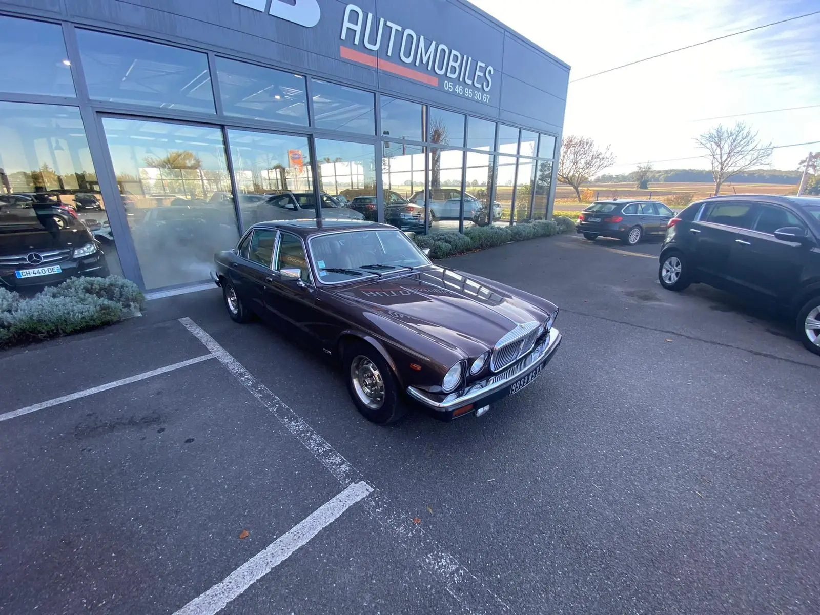 Jaguar XJ6 Série 3 4.2 Sovereign marron vue 3/4 avant droit, garée devant un showroom automobile.