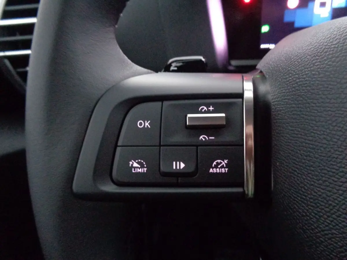 Détail des commandes au volant côté gauche de la Citroën C4 2023, avec boutons de limitation et assistance de vitesse.