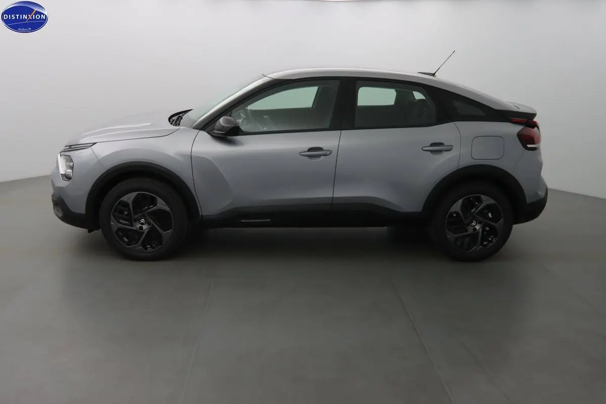 Profil côté gauche d'une Citroën C4 gris Artense métallisé 2023 avec jantes noires bicolores.