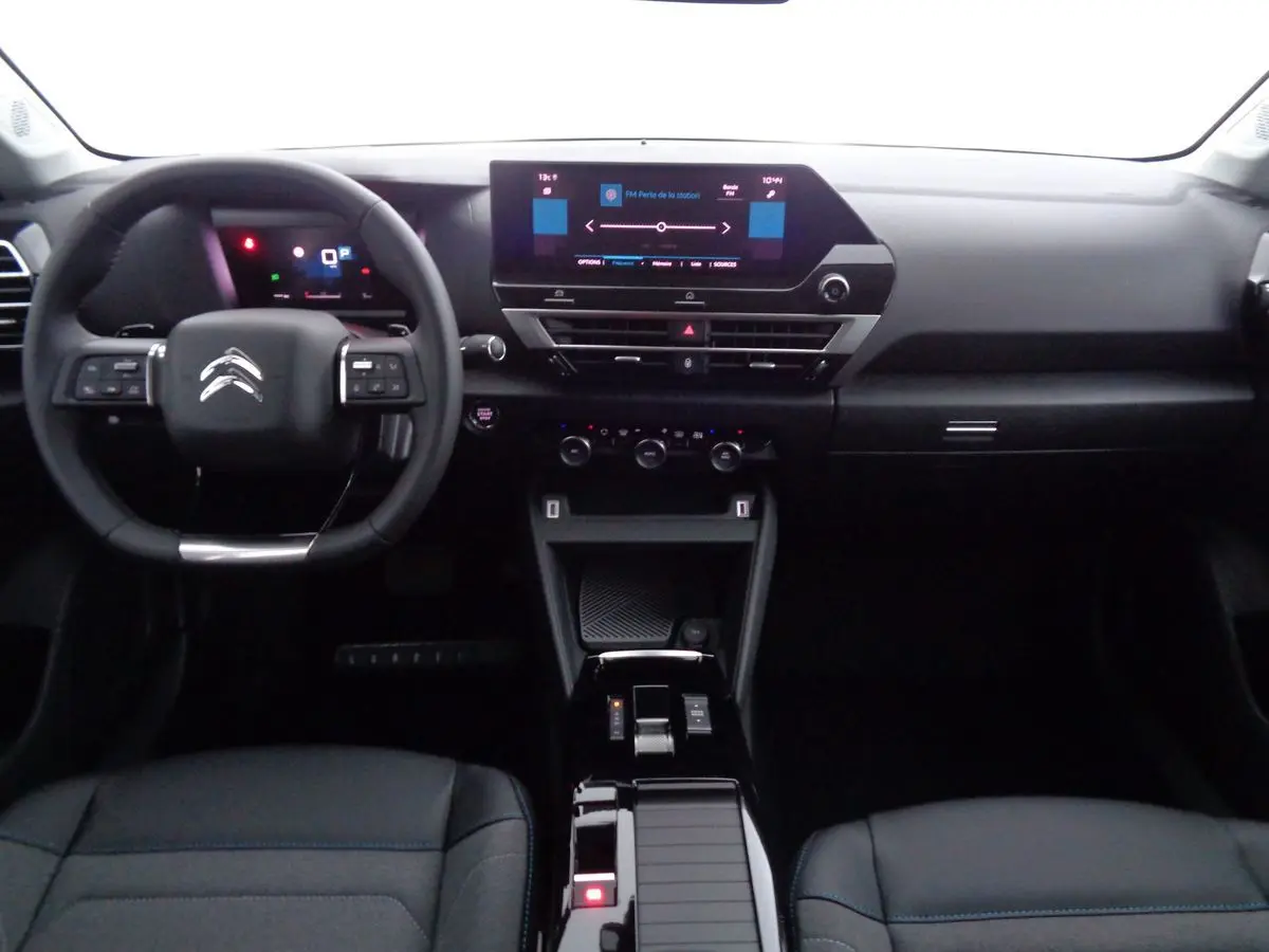 Vue intérieure du tableau de bord et volant noir du Citroën C4 2023 avec écran tactile central et console moderne.