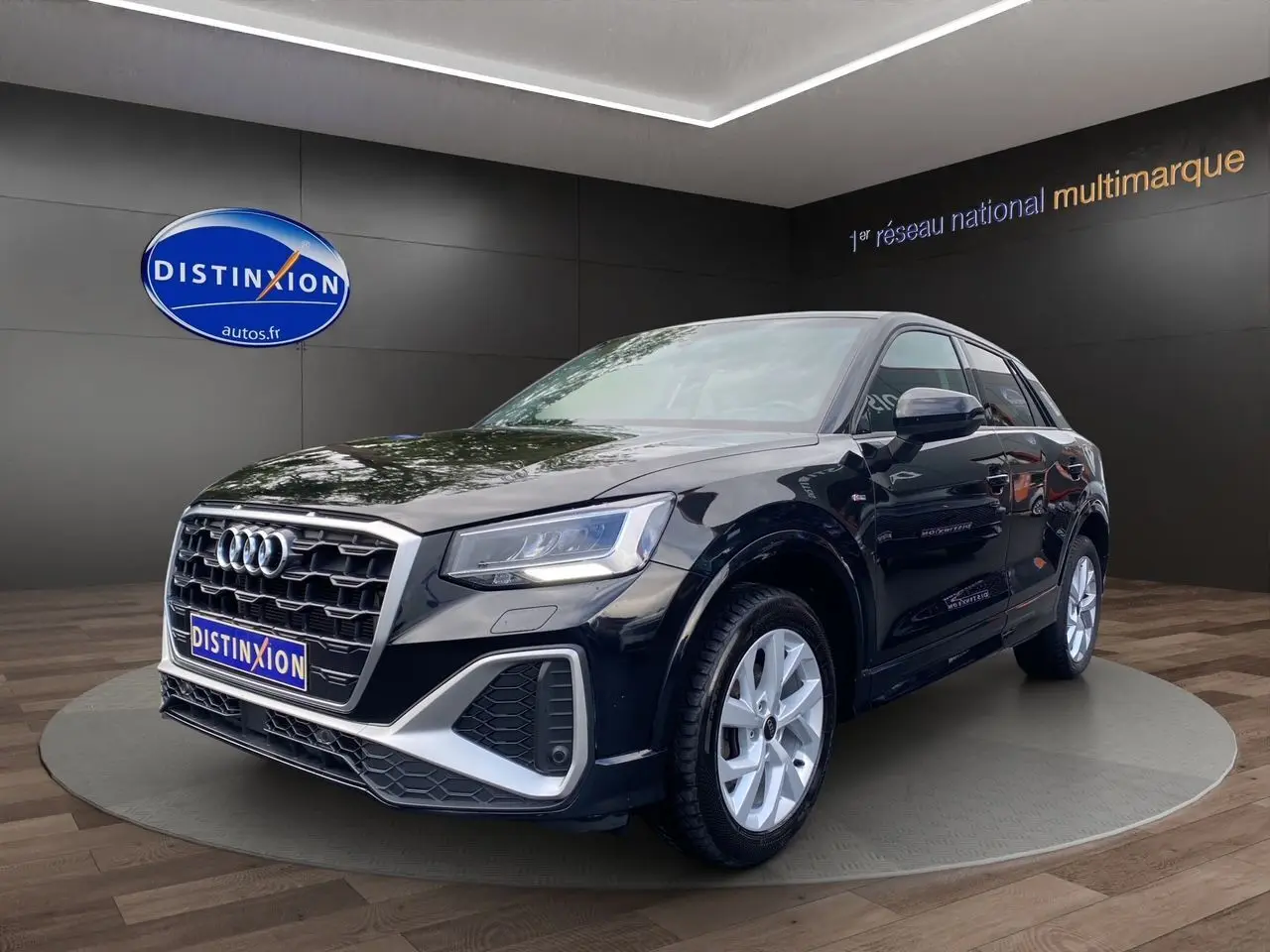 Audi Q2 noir mito en 3/4 avant droit, mettant en valeur ses jantes alliage 17 pouces et son design S-Line sportif.