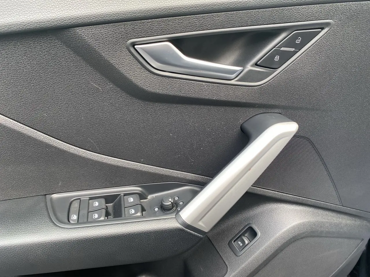 Poignée de porte intérieure côté gauche noire avec commandes de vitres et verrouillage sur Audi Q2 noir Mito 2023.