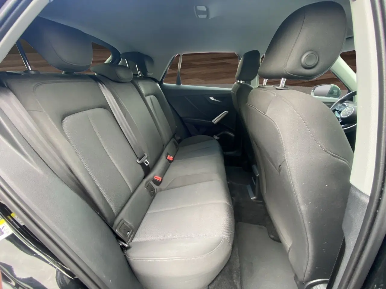 Vue intérieure côté droit montrant la banquette arrière en tissu noir du Audi Q2 35 TFSI S-Line 2023.