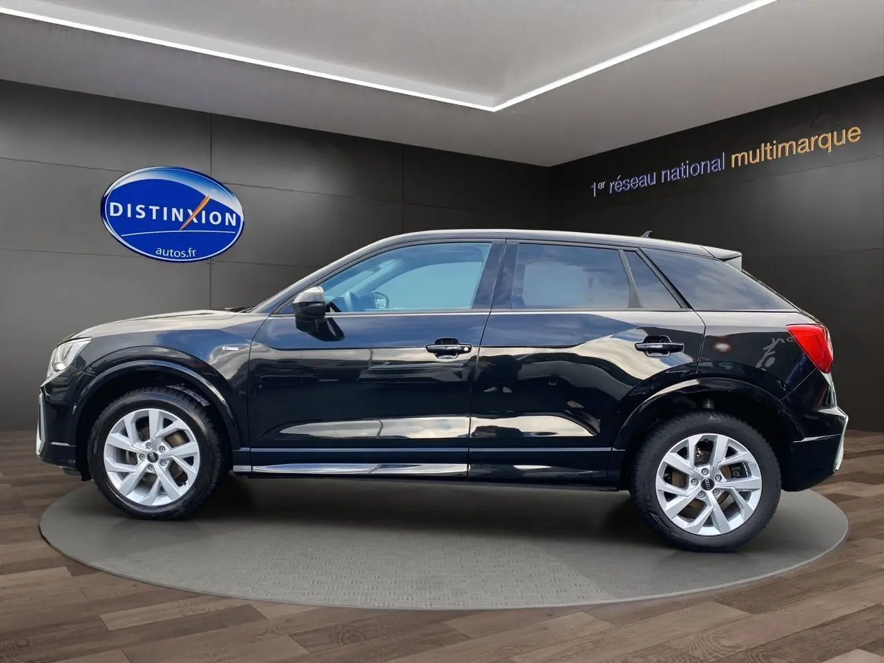 Audi Q2 noir mito vue de profil côté gauche, avec jantes alliage 17 pouces et toit panoramique visible.