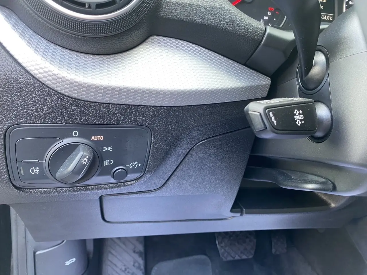 Vue rapprochée de la console centrale noire avec levier de vitesses automatique et molette de commande multimédia d'un Audi Q2.