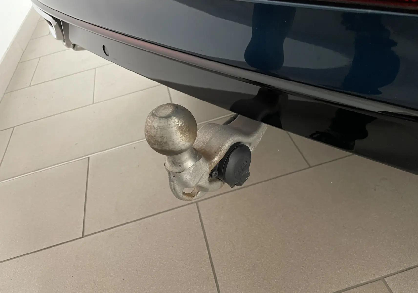 Gros plan sur le crochet d'attelage escamotable fixé à l'arrière d'un Volkswagen Tiguan 2024 bleu Nightshade.