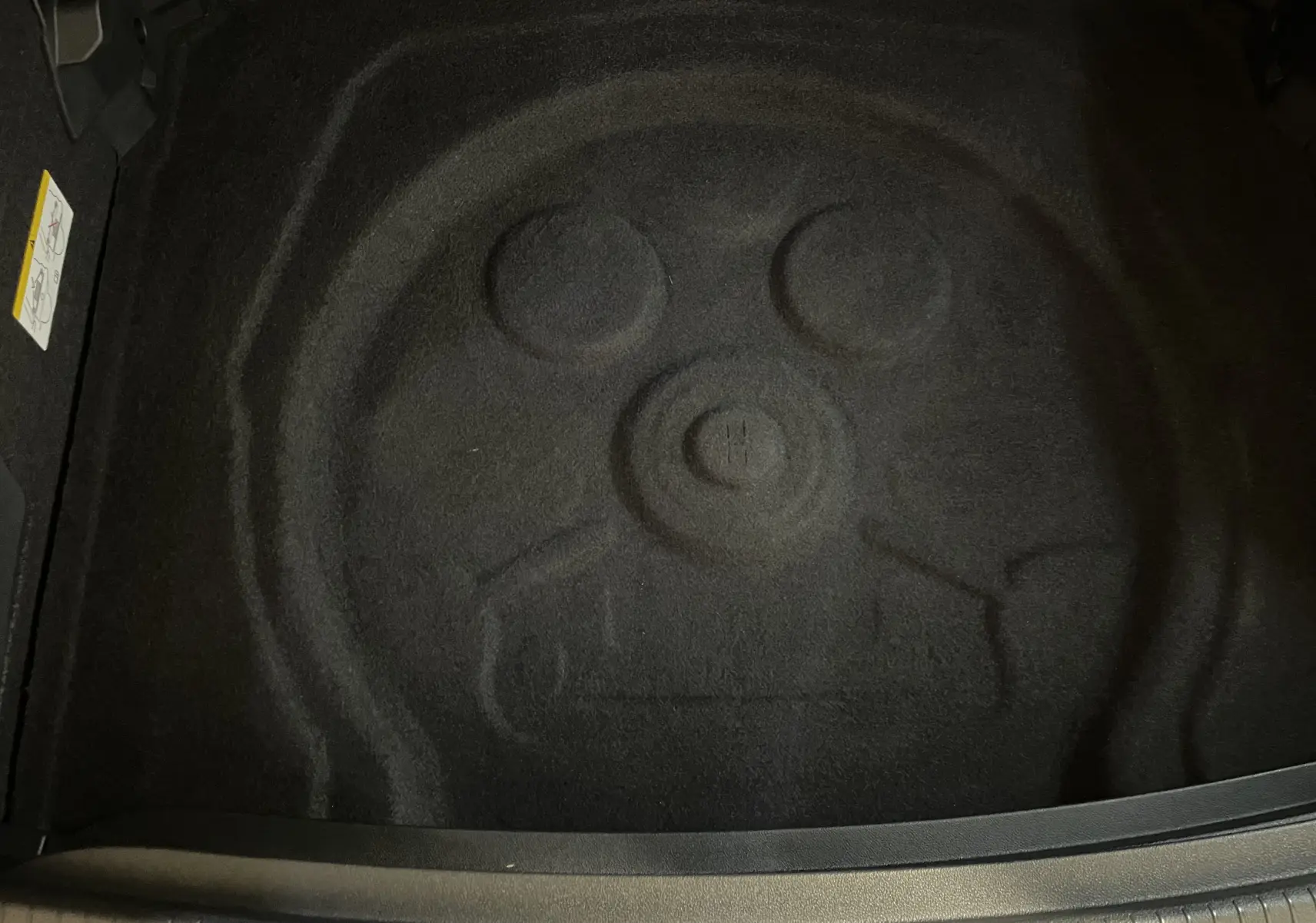 Coffre vide avec emplacement de roue de secours du Volkswagen Tiguan 2024 en Nightshade Blue, vue intérieure arrière.