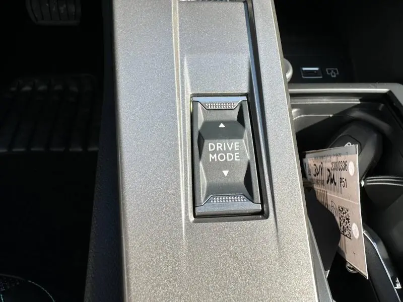 Gros plan sur le bouton Drive Mode dans la console centrale grise d'une Peugeot 308 2025 bleu Obsession.