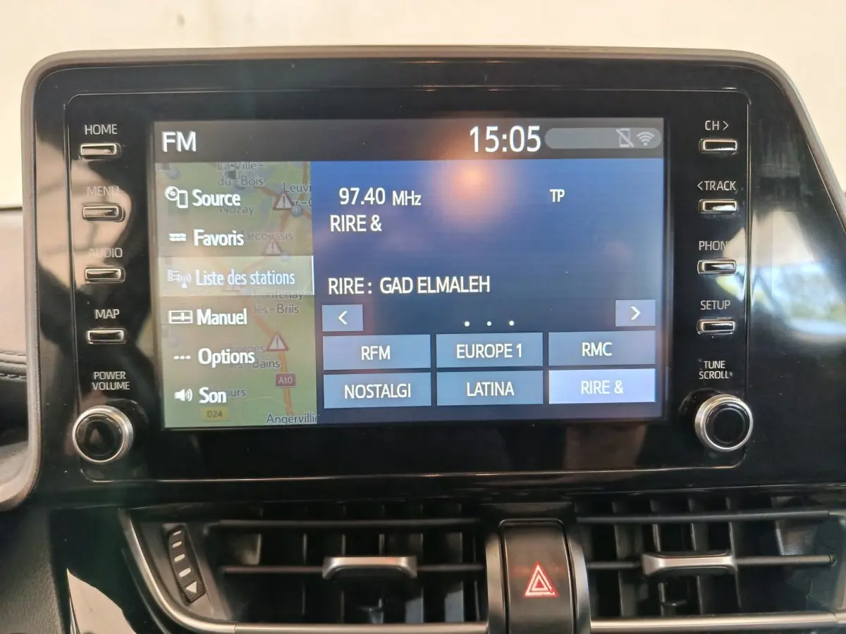 Écran tactile central du tableau de bord du Toyota C-HR 2.0 Hybride 184, affichant la radio FM à 15h05.