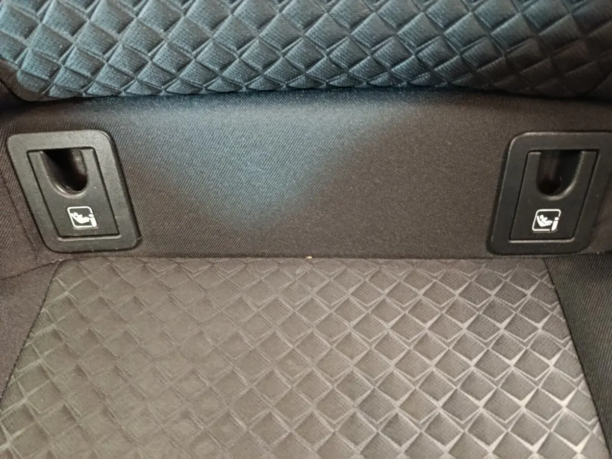 Détail de la banquette arrière en tissu gris avec attaches Isofix visibles dans un Toyota C-HR hybride 2022.