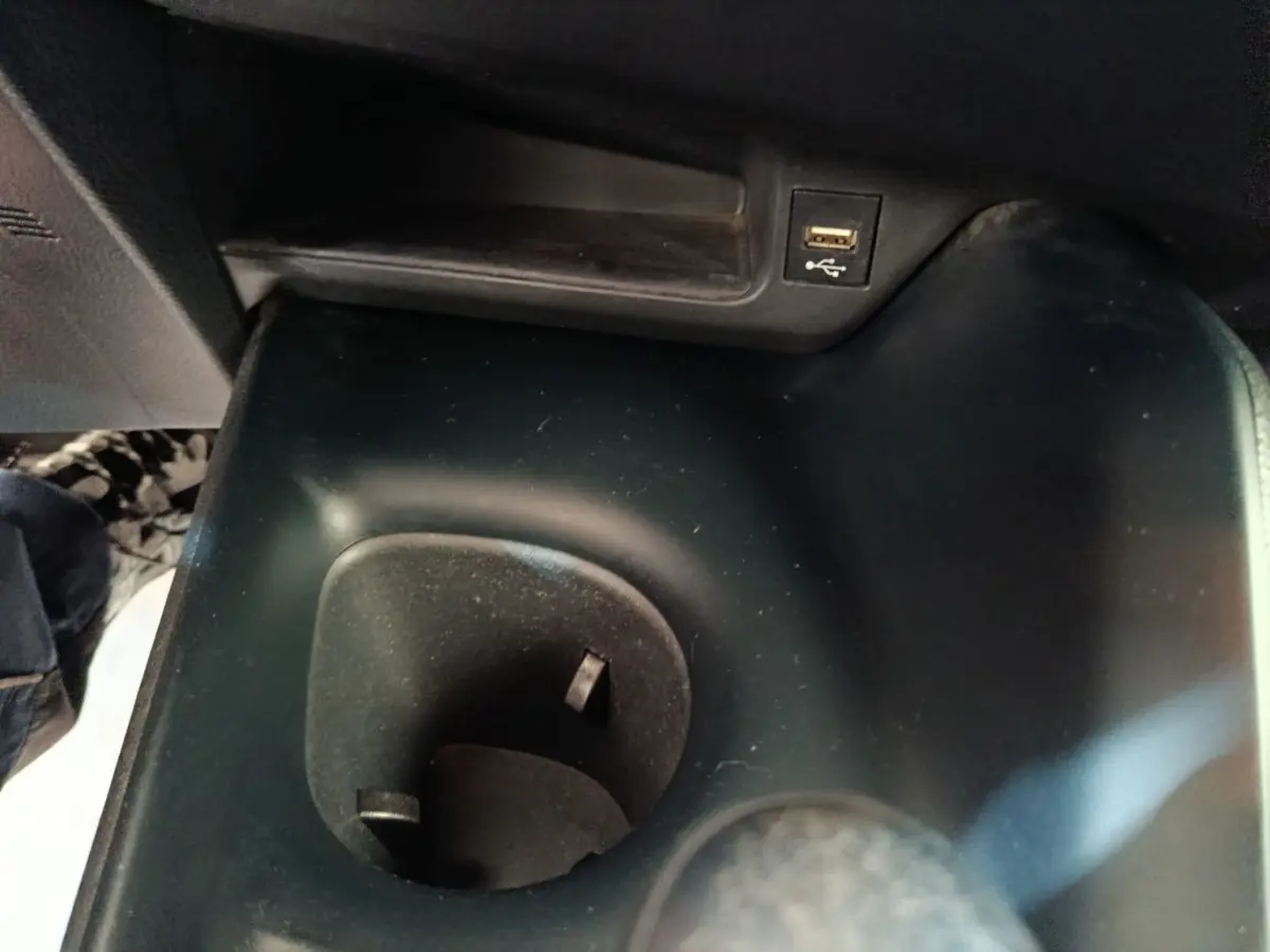 Gros plan sur le porte-gobelet noir et port USB intégré dans l'habitacle du Toyota C-HR hybride 2022.