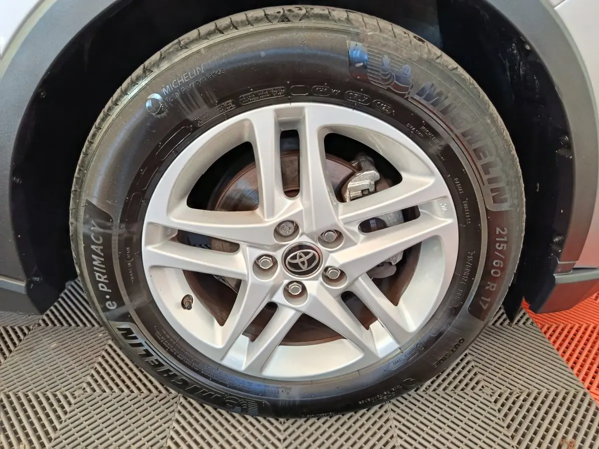 Gros plan sur la roue avant droite d’un Toyota C-HR gris clair avec jante alliage et pneu Michelin.
