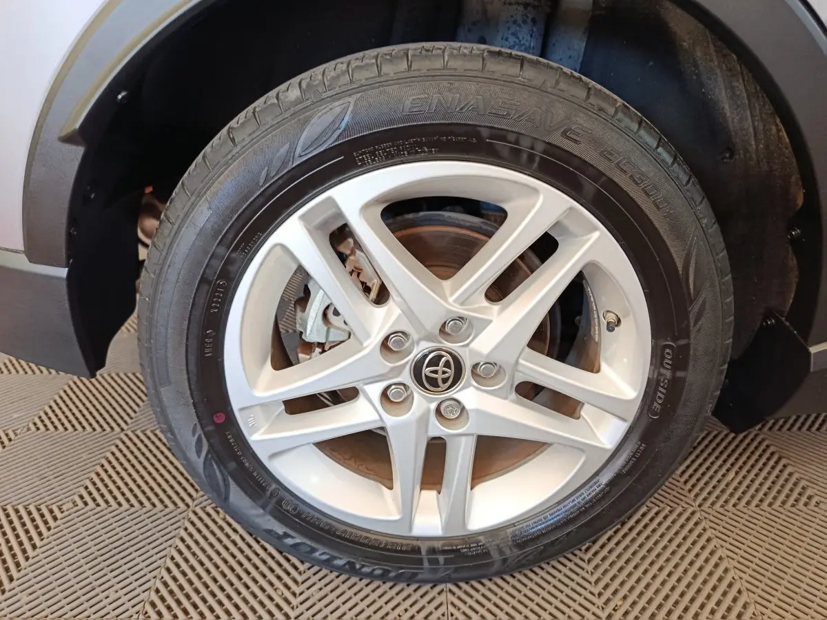 Gros plan sur la roue avant droite du Toyota C-HR gris clair, mettant en valeur la jante alliage à cinq branches.
