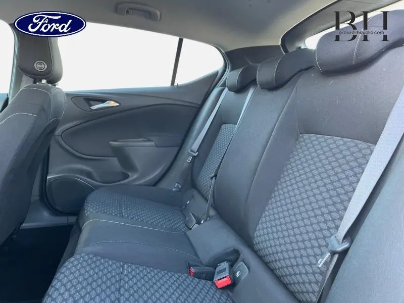 Vue intérieure de la banquette arrière noire de l'Opel Astra, avec ceinture de sécurité et appuie-têtes visibles.
