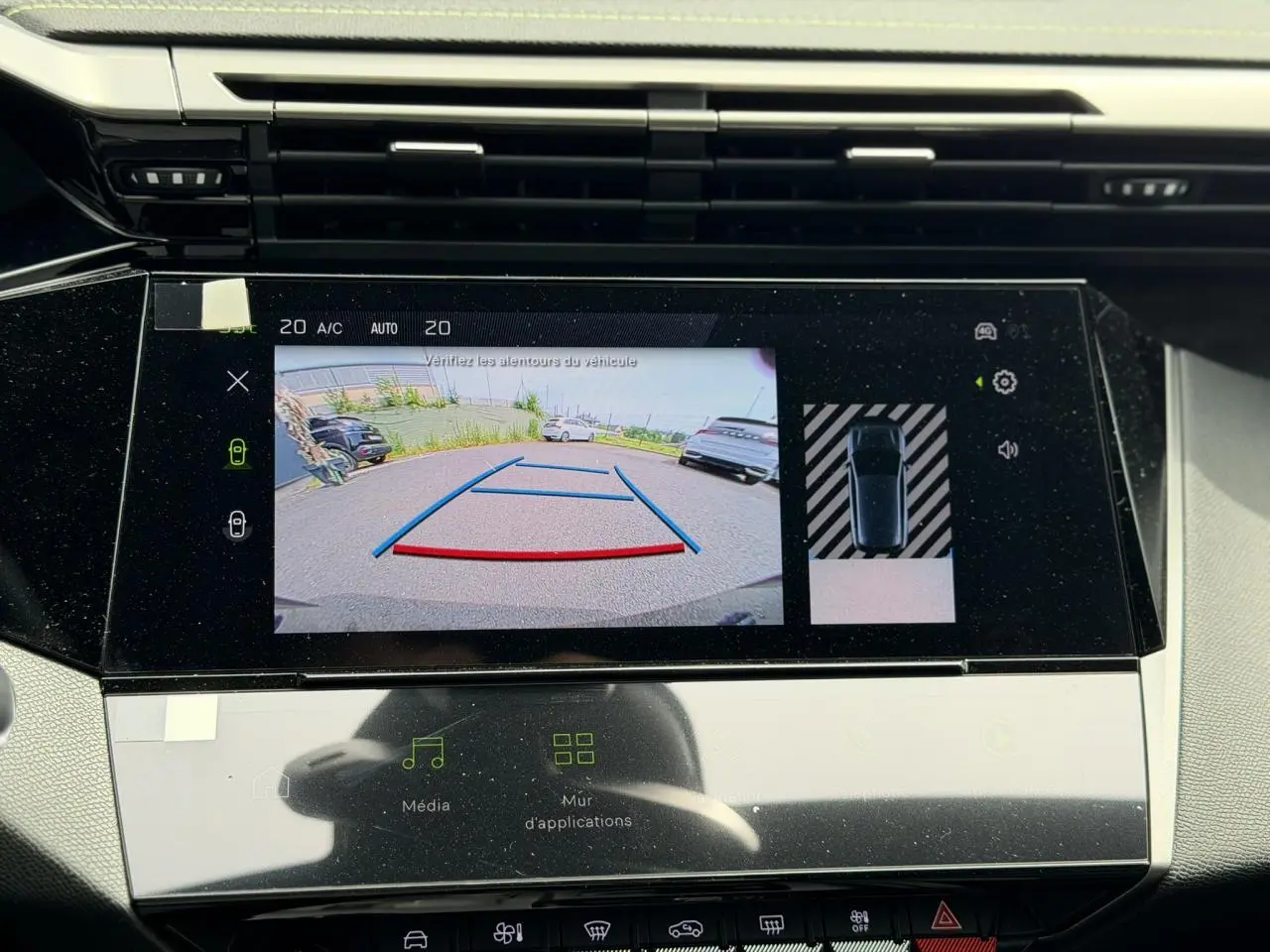 Vue rapprochée de l'écran tactile intérieur affichant la caméra de recul d'une Peugeot 308 gris Artense.