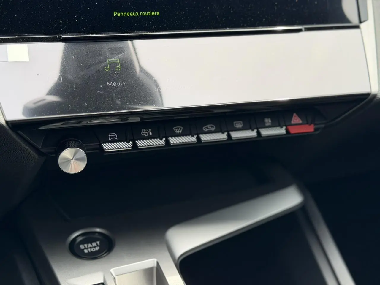 Vue rapprochée de la console centrale de la Peugeot 308 Hybrid 2026, avec écran tactile et boutons de commande noirs.