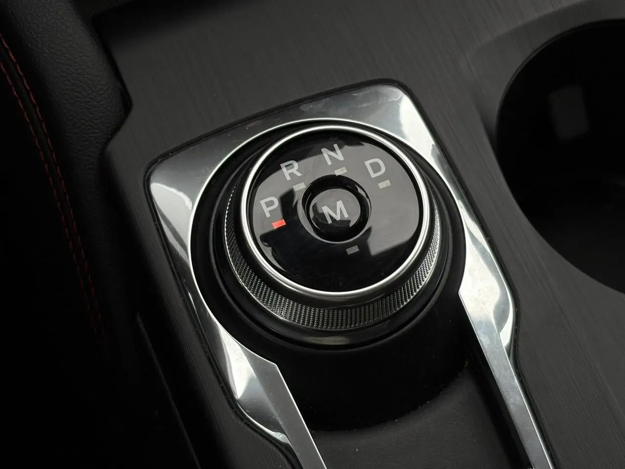 Gros plan sur le sélecteur rotatif de boîte automatique noir et chrome dans l’habitacle du Ford Kuga gris graphite.