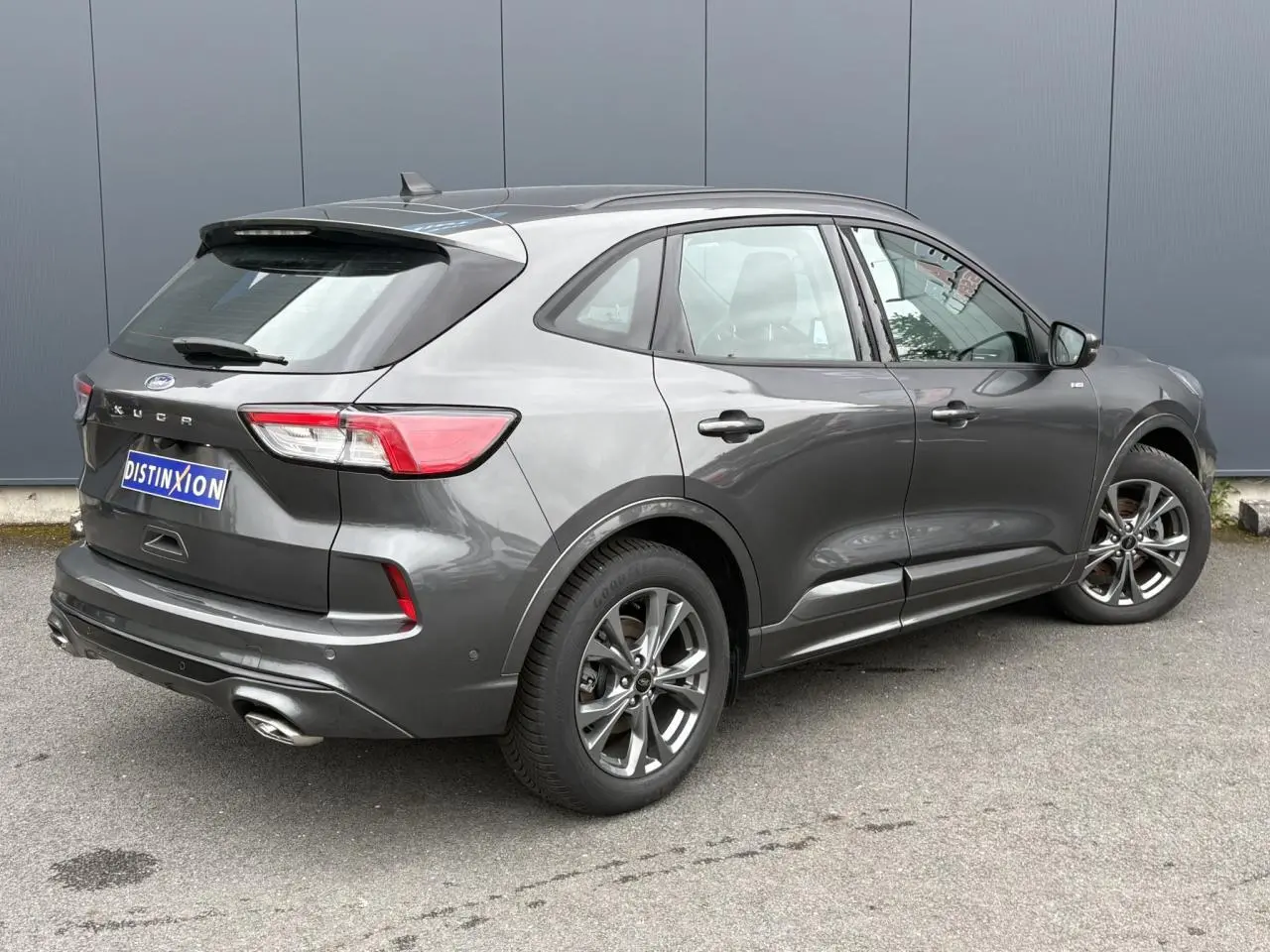 Vue 3/4 arrière droit du Ford Kuga 2.0 EcoBlue gris graphite avec jantes alliage et double sortie d’échappement ST-Line.