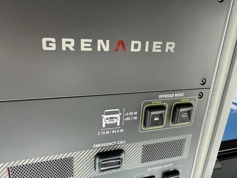 Détail du tableau de bord du INEOS Grenadier 2024 beige, montrant les commandes du mode offroad et les dimensions du véhicule.