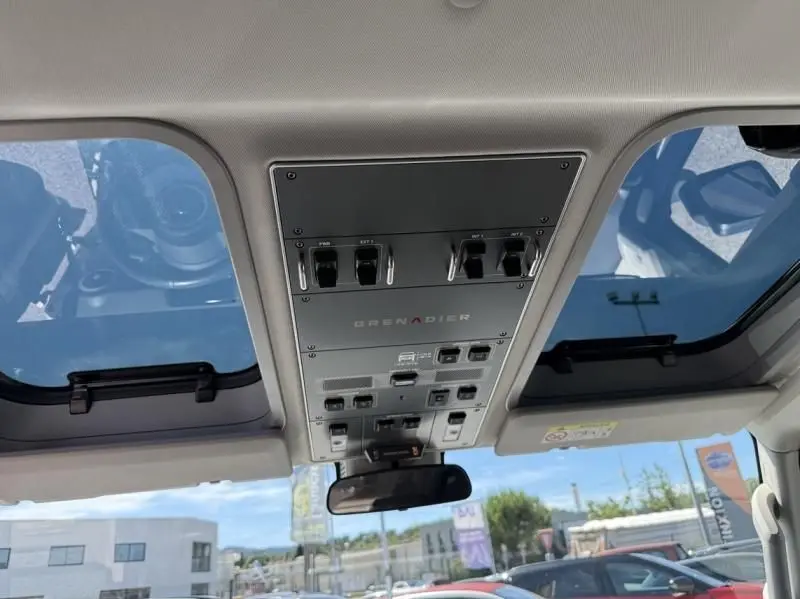 Vue intérieure du plafond avec panneau de commandes et toit ouvrant du INEOS Grenadier 3.0 TD beige 2024.
