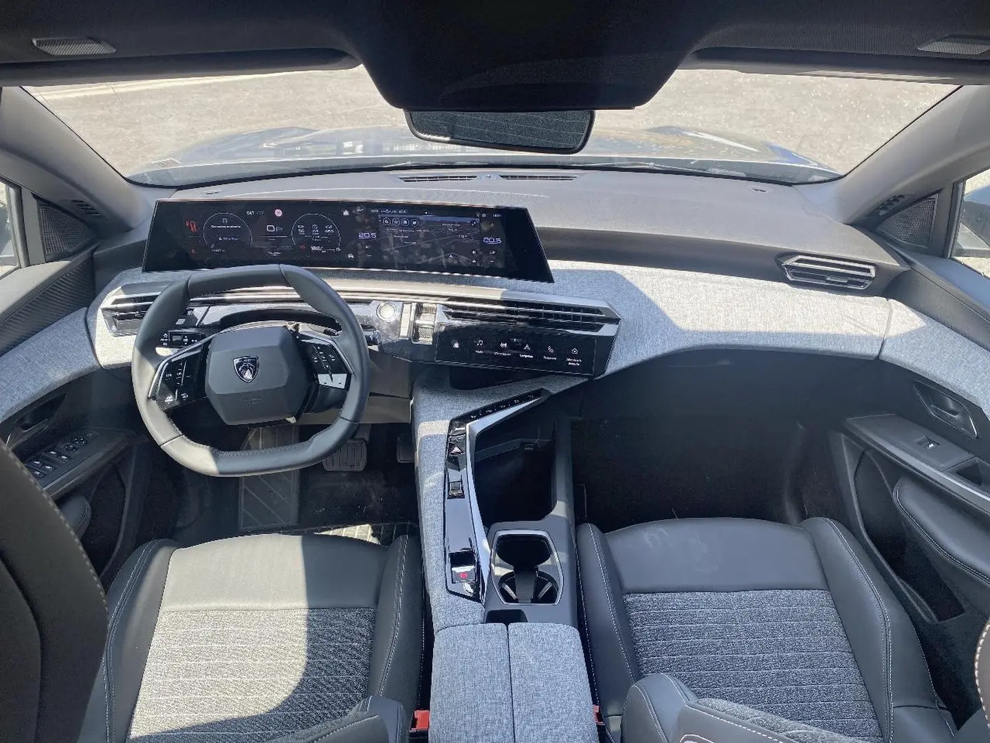 Vue intérieure avant du Peugeot 5008 Hybrid 145 allure e-dcs6 2025, avec tableau de bord numérique et sellerie gris clair.