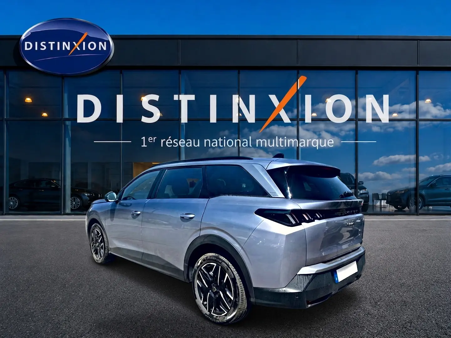 Peugeot 5008 Hybrid 145 allure gris artense en 3/4 arrière droit, avec jantes alu et feux arrière LED distinctifs.