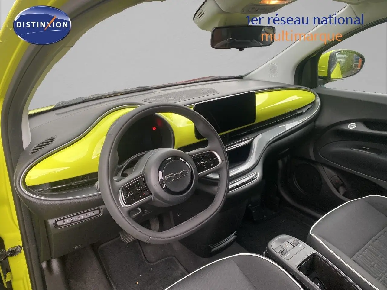 Intérieur avant droit de la FIAT 500 électrique jaune acid avec tableau de bord et volant noirs et jaunes.