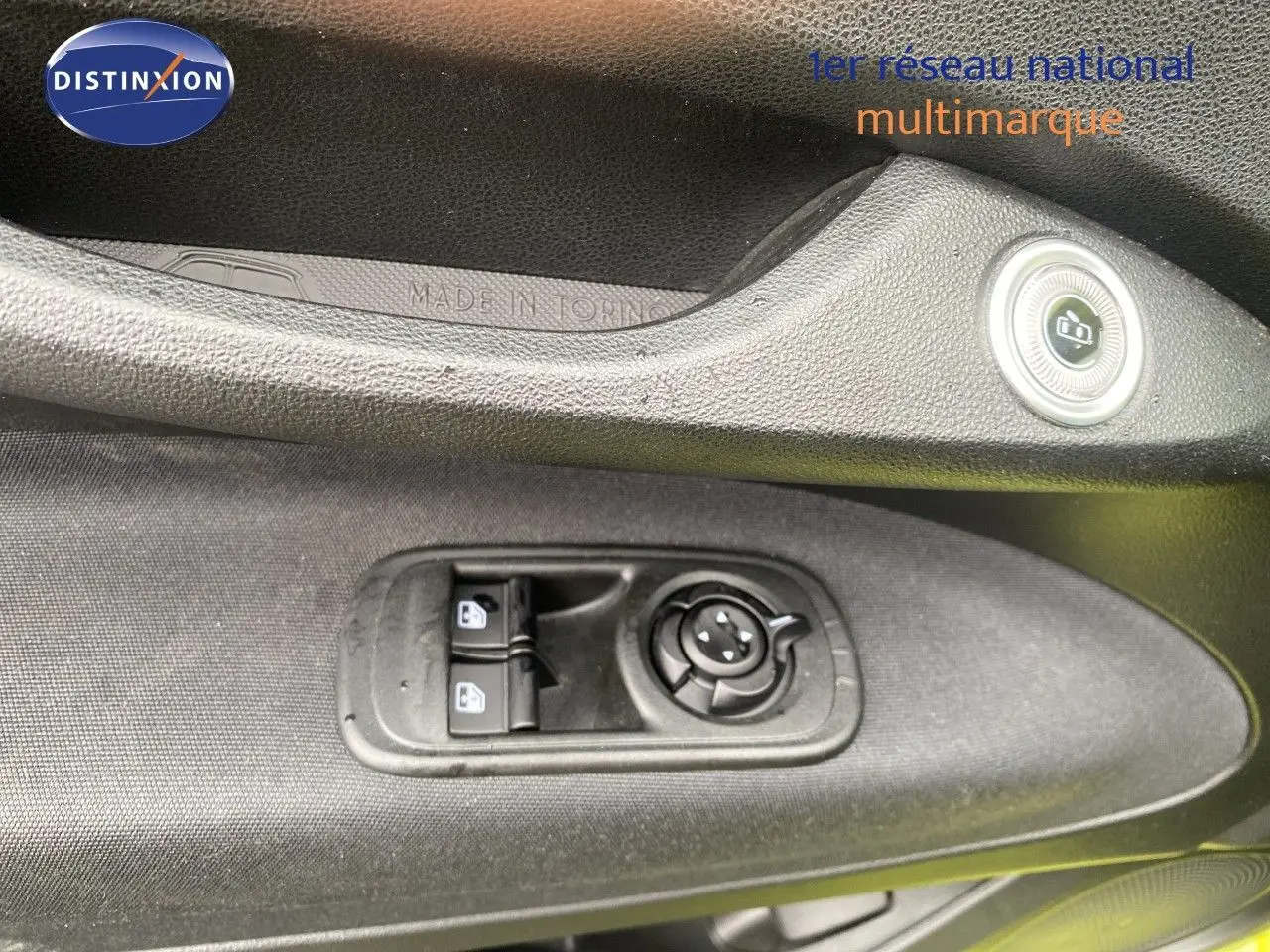 Gros plan sur les commandes de lève-vitres et réglage des rétroviseurs côté conducteur d'une FIAT 500 électrique jaune acid 2024.