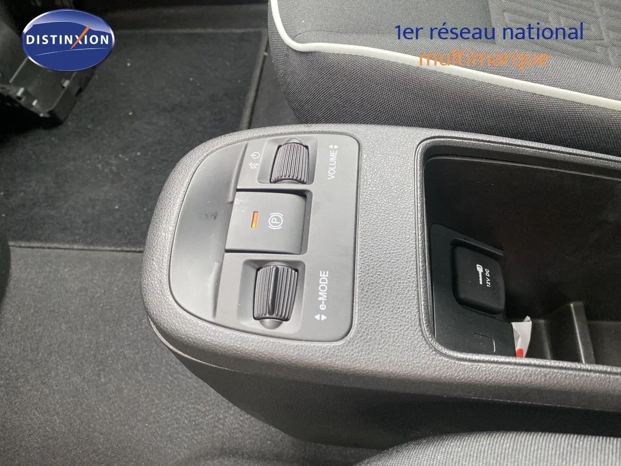 Gros plan sur la console centrale de la Fiat 500 électrique 2024, montrant les commandes e-mode et volume.