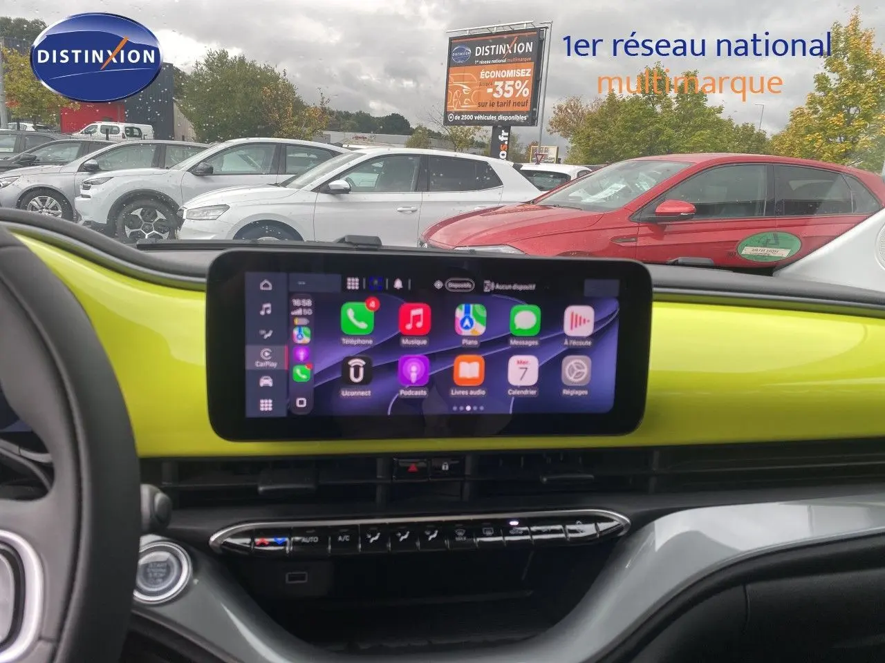 Vue intérieure du tableau de bord de la FIAT 500 électrique 2024 en jaune acid, avec écran tactile central allumé.