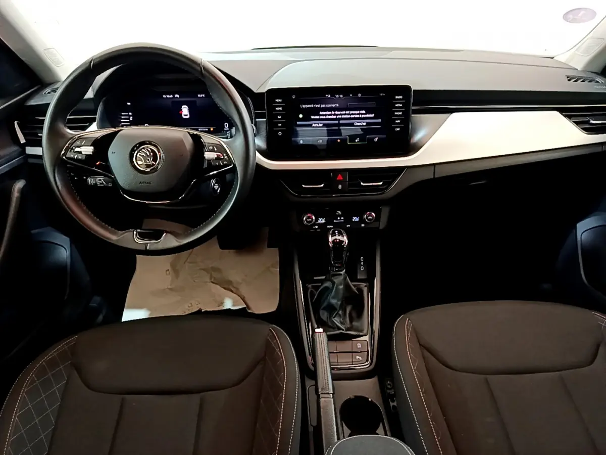 Intérieur noir du Skoda Kamiq 2022 vu de face, tableau de bord moderne avec écran tactile et volant multifonctions.