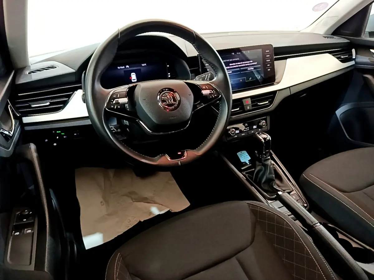 Intérieur du Skoda Kamiq 2022 vu côté conducteur, volant cuir, tableau de bord digital et console centrale noire.