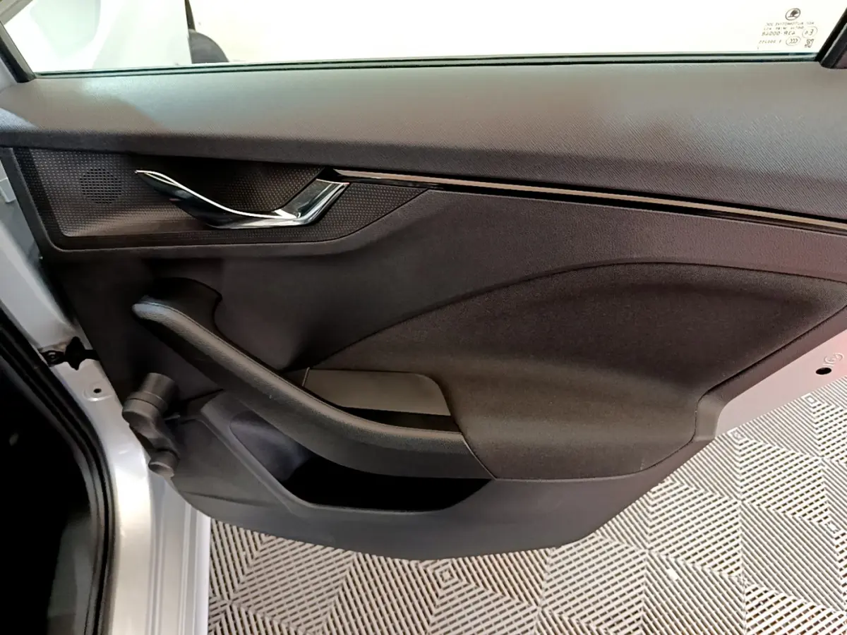 Gros plan sur la porte arrière gauche gris clair du Skoda Kamiq 2022, avec poignée chromée et panneau noir texturé.