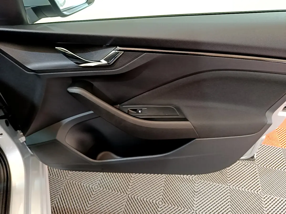 Vue rapprochée de la porte avant gauche gris clair du Skoda Kamiq 2022 avec poignée intégrée et garniture noire.