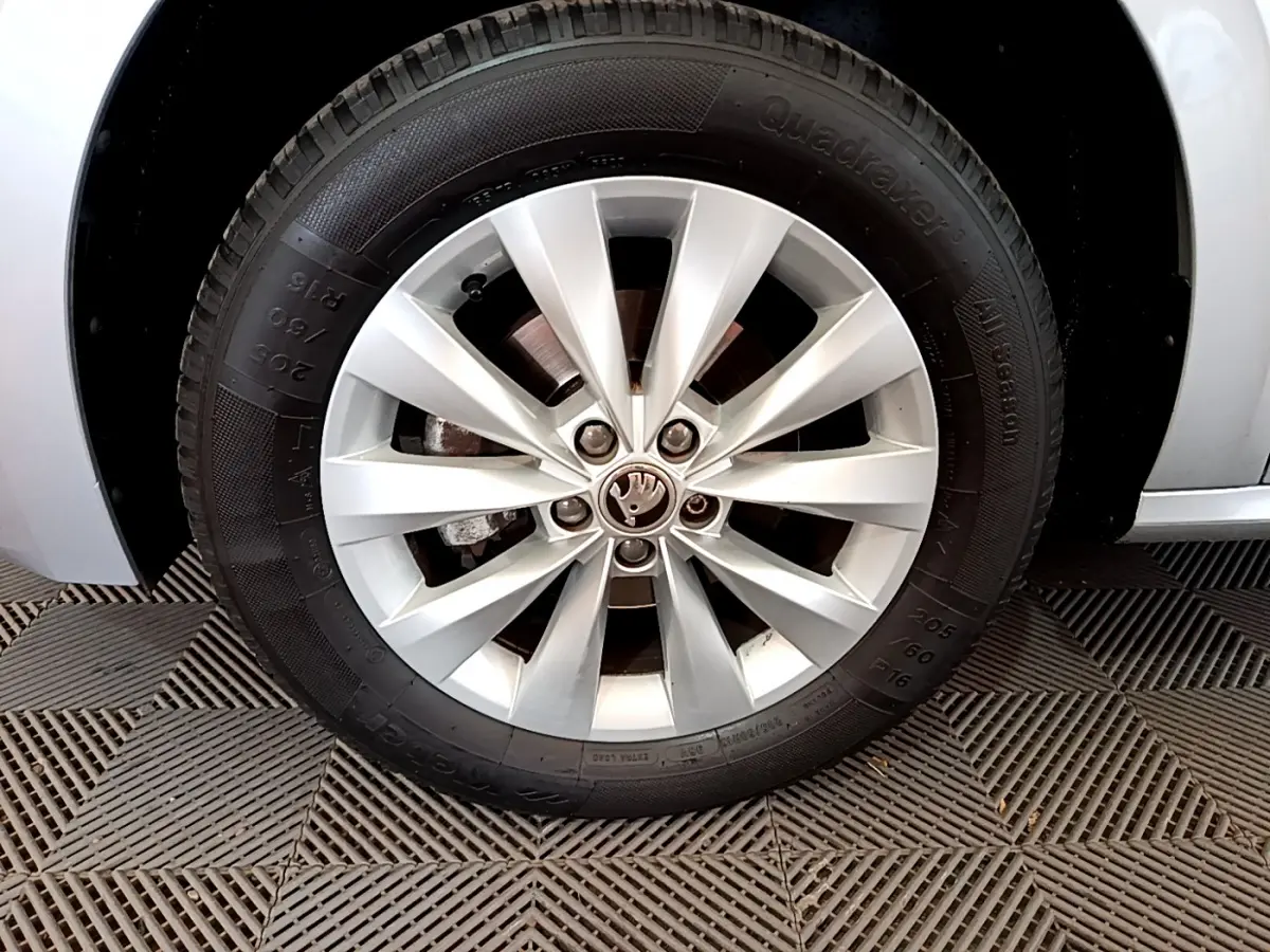 Gros plan sur la roue avant gauche gris clair d’un Skoda Kamiq 1.0 TSI 110ch DSG7 Business avec jante alliage à 10 branches.