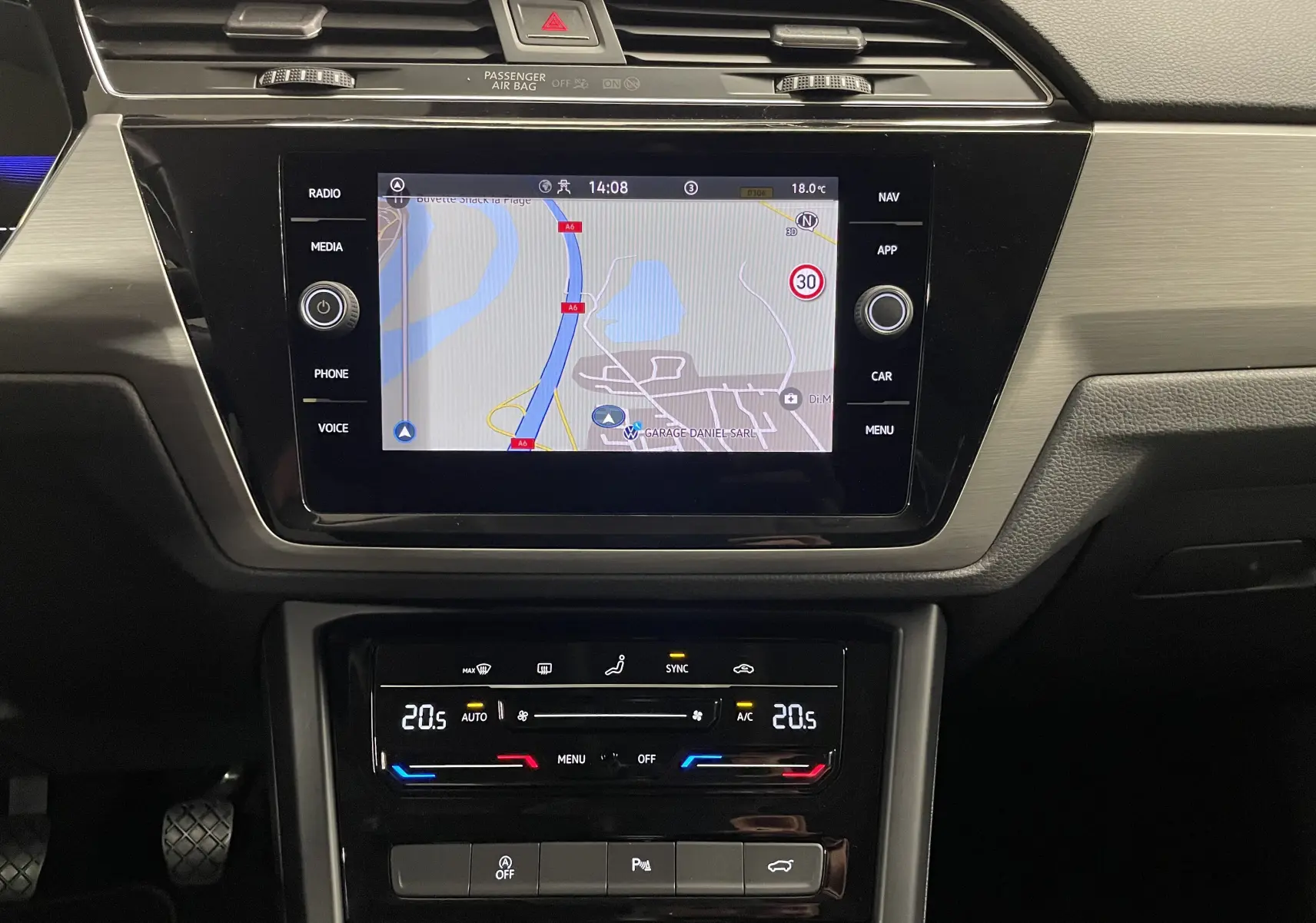 Vue rapprochée de la console centrale du Volkswagen Touran 2024 avec écran tactile et commandes climatisation digitales.