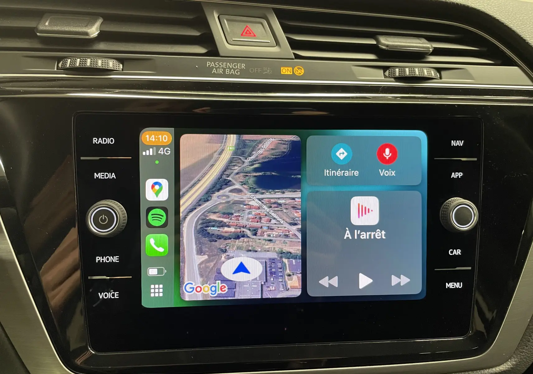 Écran tactile central du Volkswagen Touran 2024 affichant navigation Google Maps et commandes vocales, tableau de bord noir brillant.
