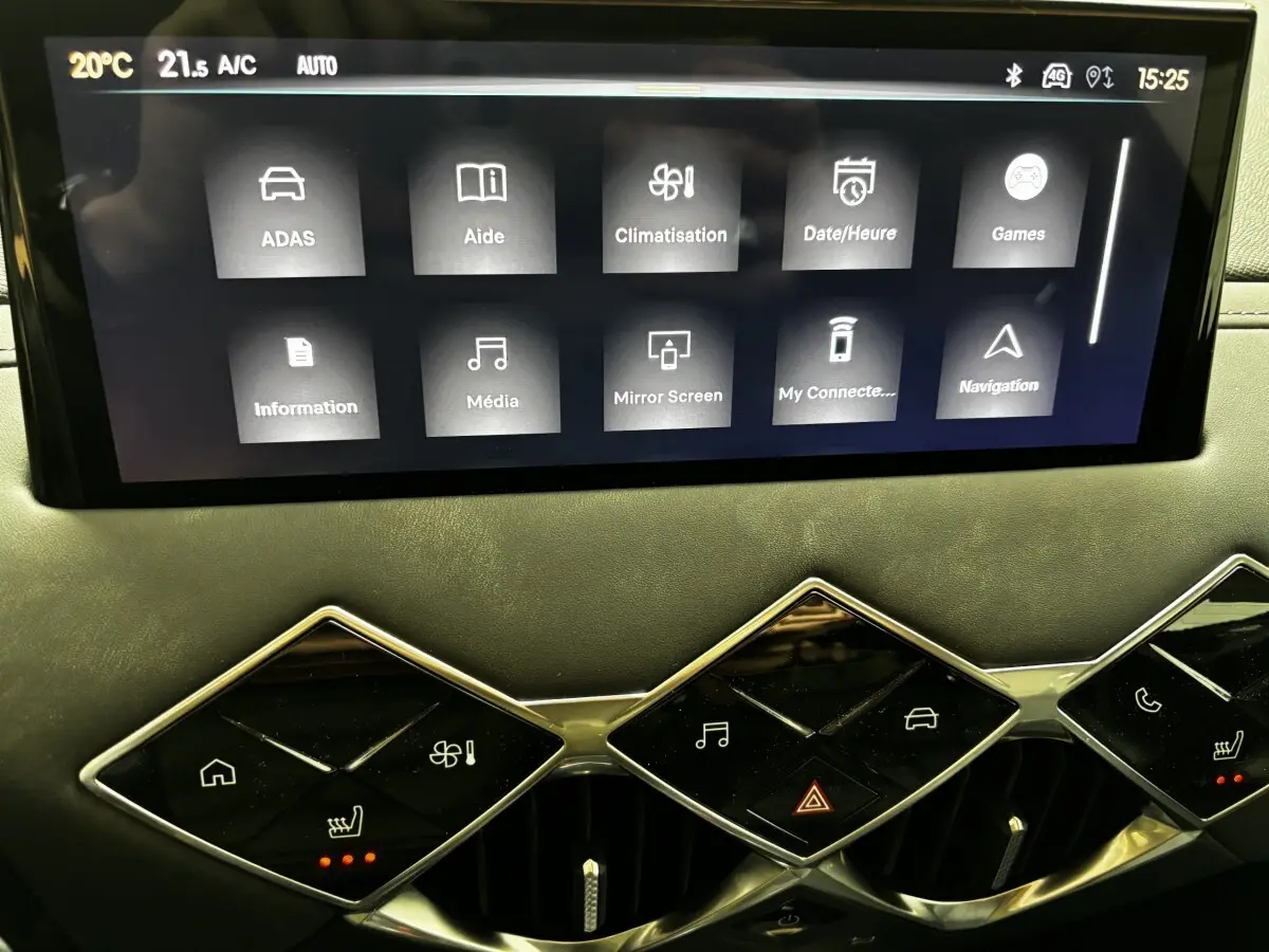 Gros plan sur l'écran tactile central et les commandes en losange du tableau de bord du DS3 noir, version 2024.