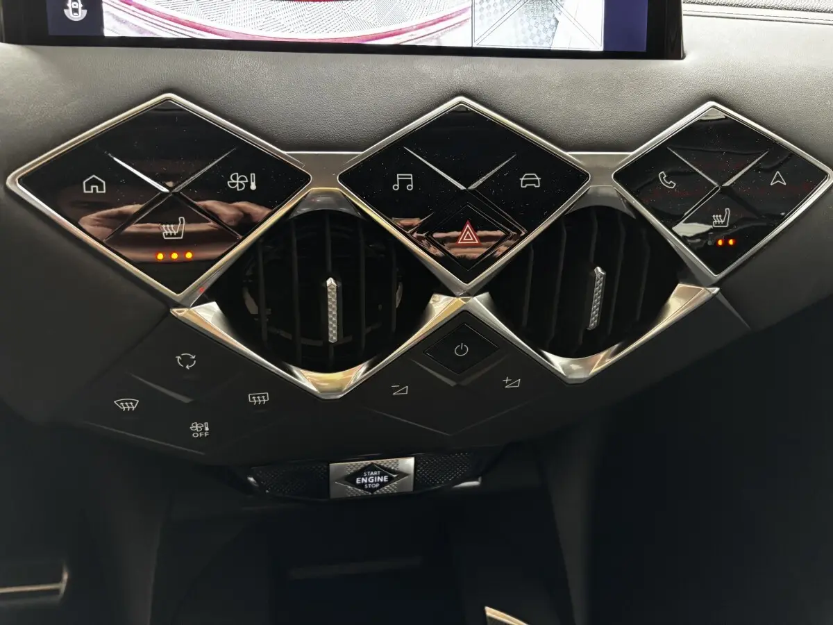 Détail du tableau de bord noir de la DS3 2024 avec commandes en losange et boutons tactiles lumineux.