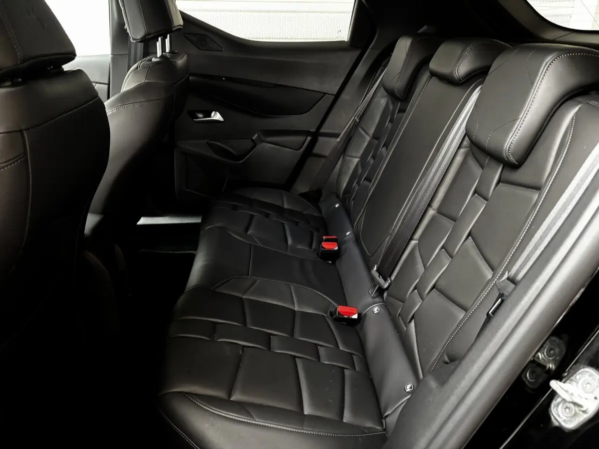Vue latérale droite de la banquette arrière en cuir noir du DS3 2024 avec ceintures et appuie-têtes intégrés.