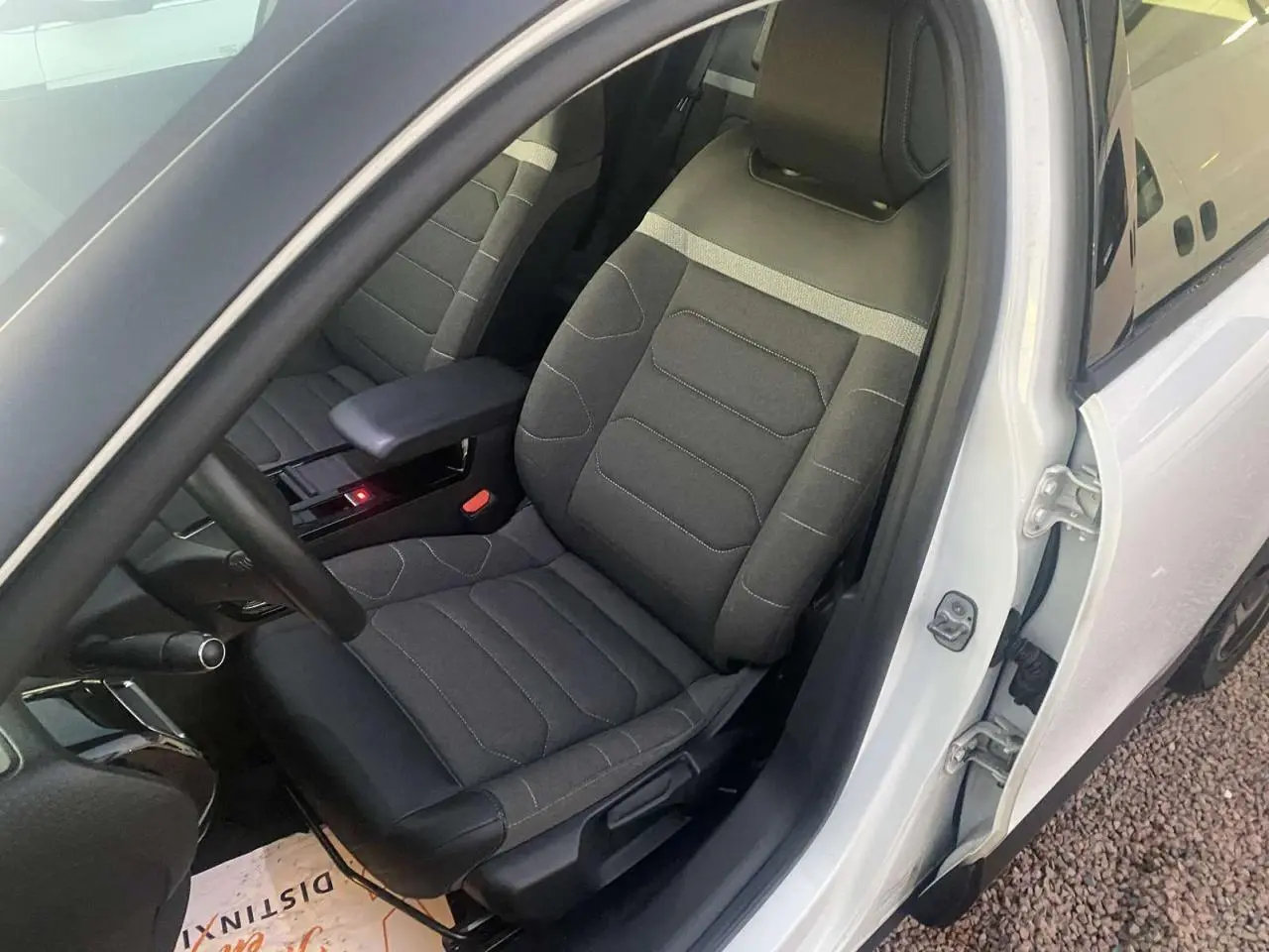 Vue intérieure côté conducteur du siège avant gris foncé avec détails blancs d'une Citroën C4 blanche 2021.