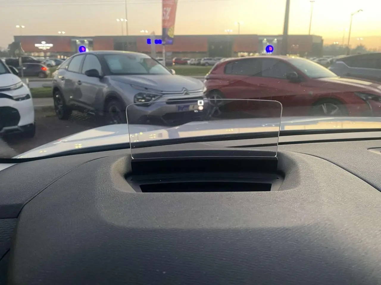 Vue intérieure du tableau de bord de la Citroën C4 blanche 2021 avec affichage tête haute transparent en position relevée.
