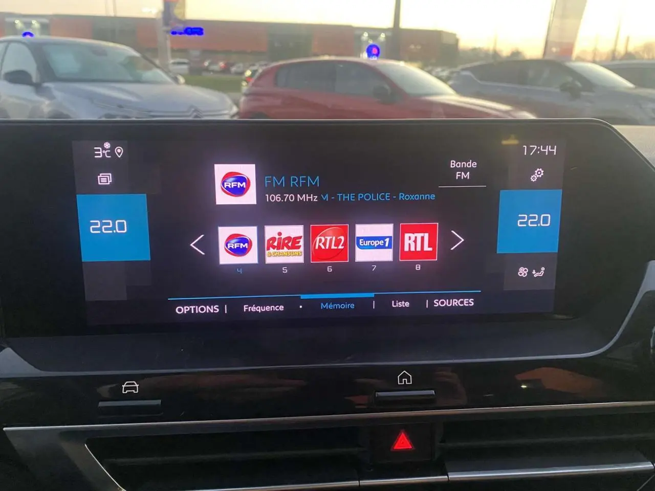 Écran tactile central de la Citroën C4 blanche 2021 affichant les stations radio FM en soirée.