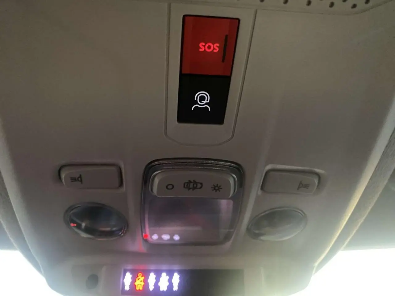 Vue intérieure du plafond avant d'une Citroën C4 blanche 2021, avec bouton SOS rouge et commandes d'éclairage.