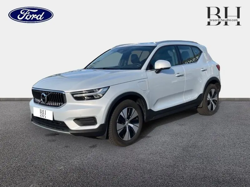 Vue 3/4 avant droite d'un Volvo XC40 T5 Recharge gris glacier avec calandre chromée et jantes alu noires et argentées.