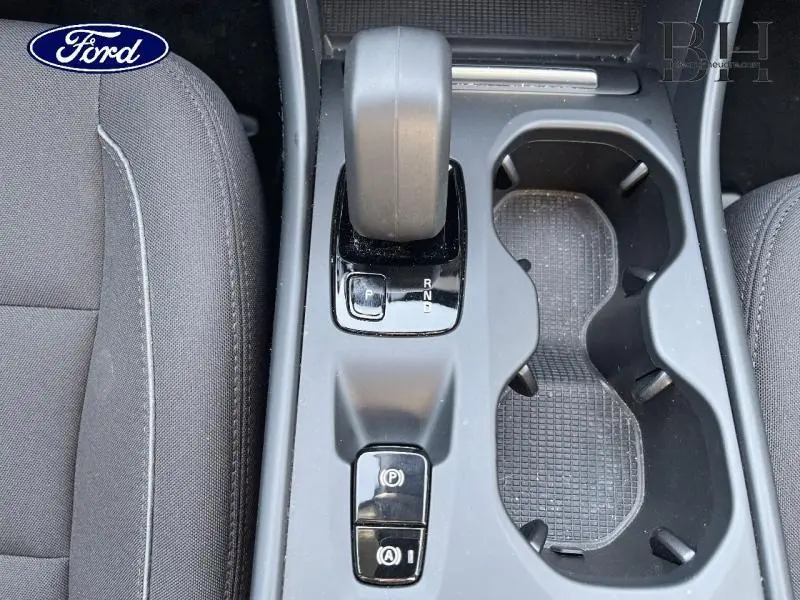 Gros plan sur la console centrale grise avec levier de vitesses automatique et porte-gobelets du Volvo XC40 T5 Recharge.