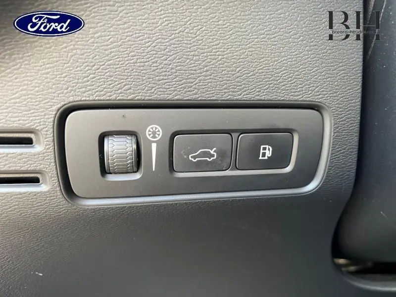 Gros plan sur les commandes intérieures noires du tableau de bord du Volvo XC40 T5 Recharge gris Glacier.
